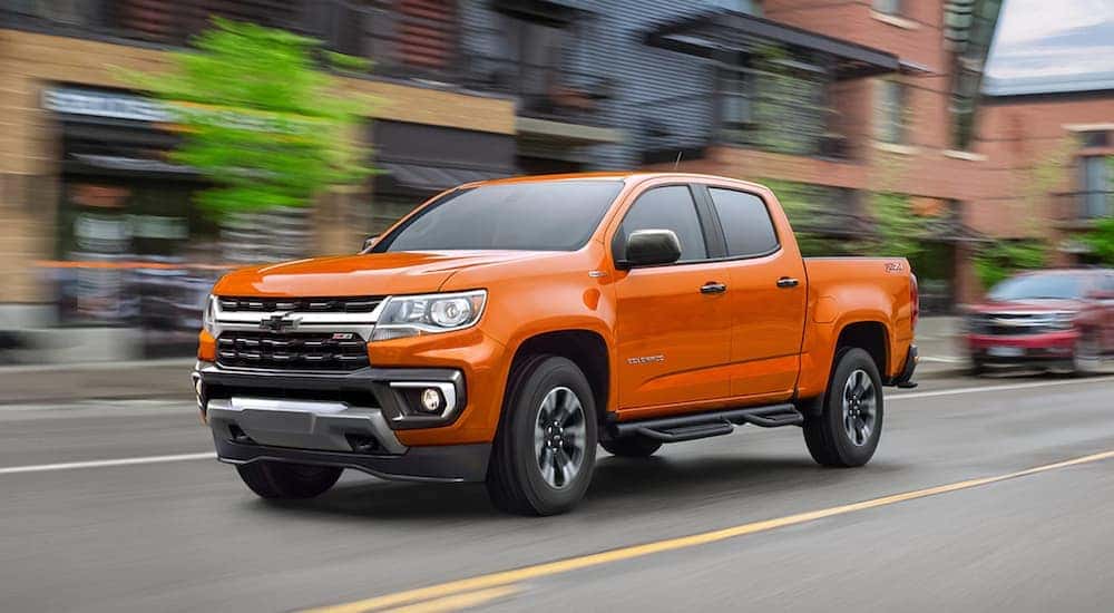 A orange 2021 Chevy Colorado Z71 is driving down the road after visiting an Atlanta Chevy dealer.