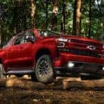 A red 2018 used Chevy Silverado RST is parked in the woods.