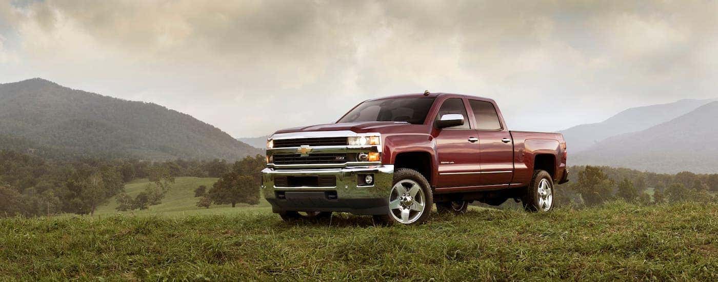A dark red 2018 Chevy Silverado 2500HD is parked on a field.