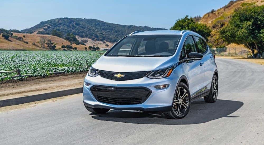 A silver 2018 Chevy Bolt EV, popular among Atlanta used cars, is parked next to crops