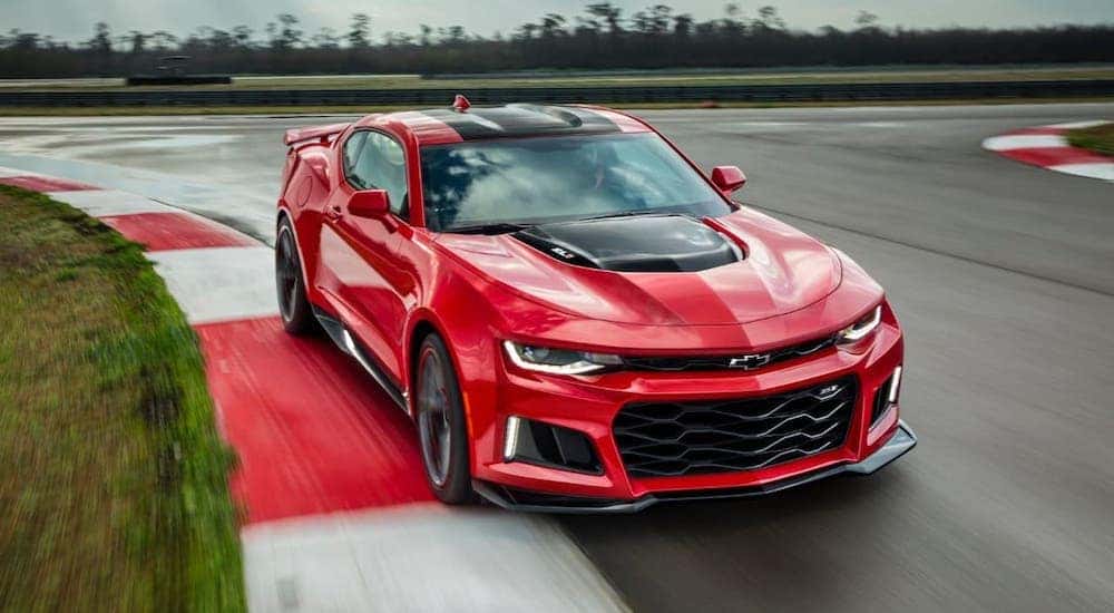 A red 2021 Chevy Camaro ZL1 is driving on a race track after leaving a Chevrolet dealer in Atlanta.