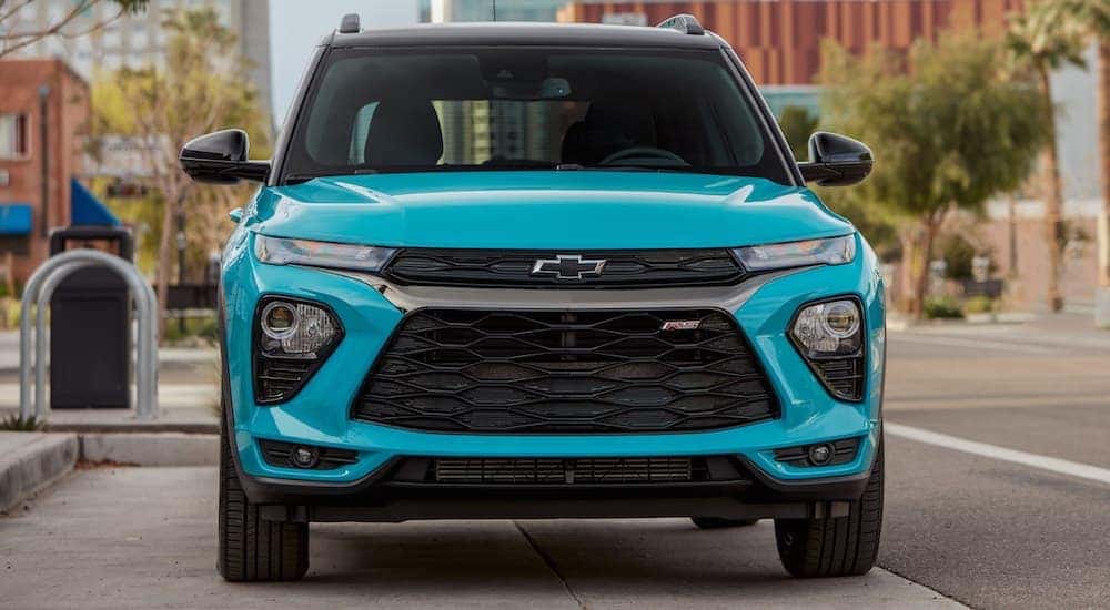 A teal 2021 Chevy Trailblazer is parked on a city street, shown from the front.