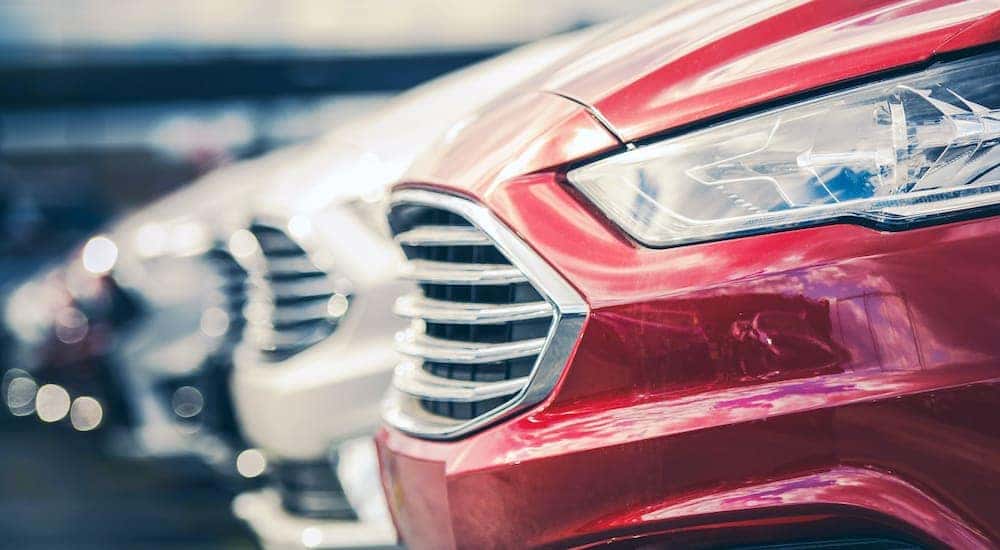 A row of cars are parked at a certified pre-owned Chevy dealership.