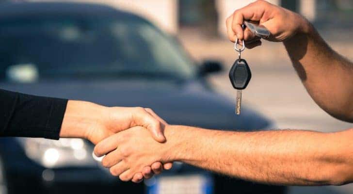 A salesman is shaking hands at an Atlanta used Chevy dealer.