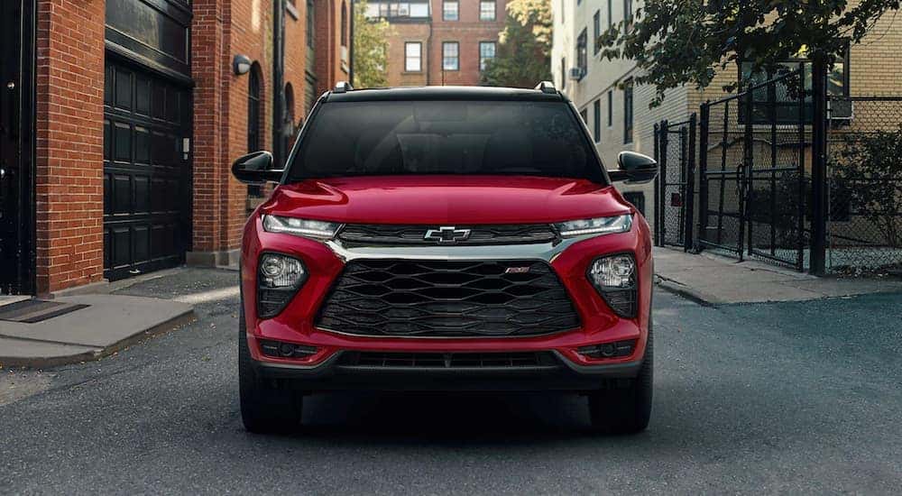 A red 2022 Chevy Trailblazer RS is shown from the front driving through a city after looking at Chevy lease deals.