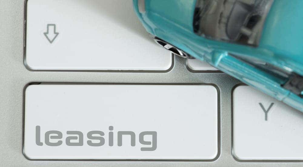 A keyboard shows a leasing button next to a toy car.