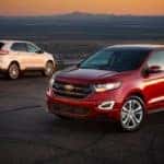 A red and white 2015 Ford Edge are shown parked in an empty parking lot.