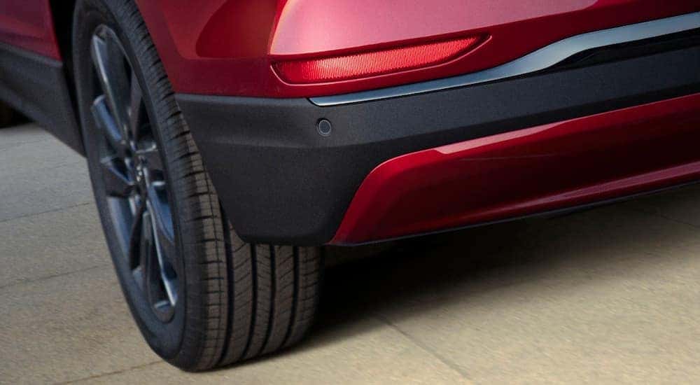The rear tire of a red 2022 Chevy Equinox RS is shown during a Chevy end of lease inspection.