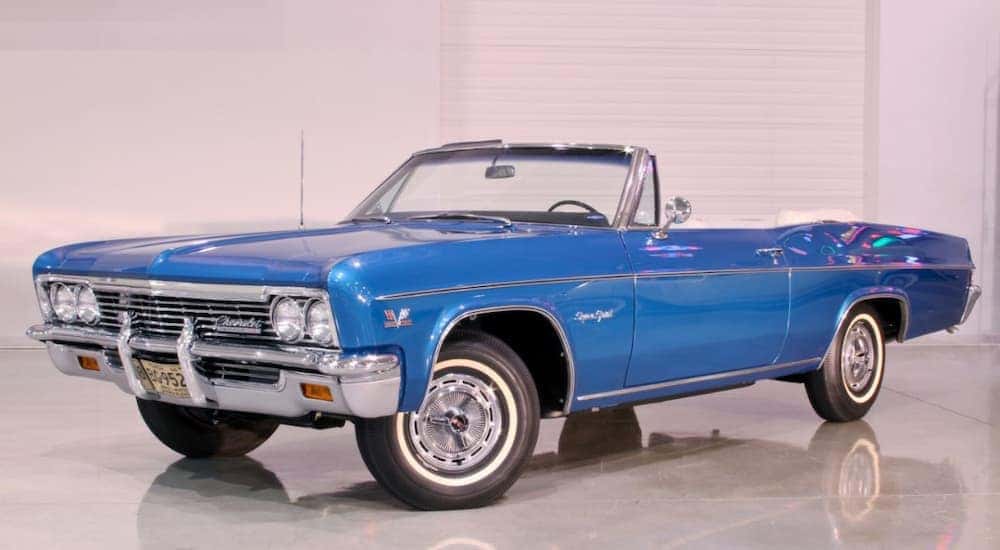 A blue 1966 Chevy Impala SS is shown parked in a showroom near used Chevrolet dealers in Atlanta.