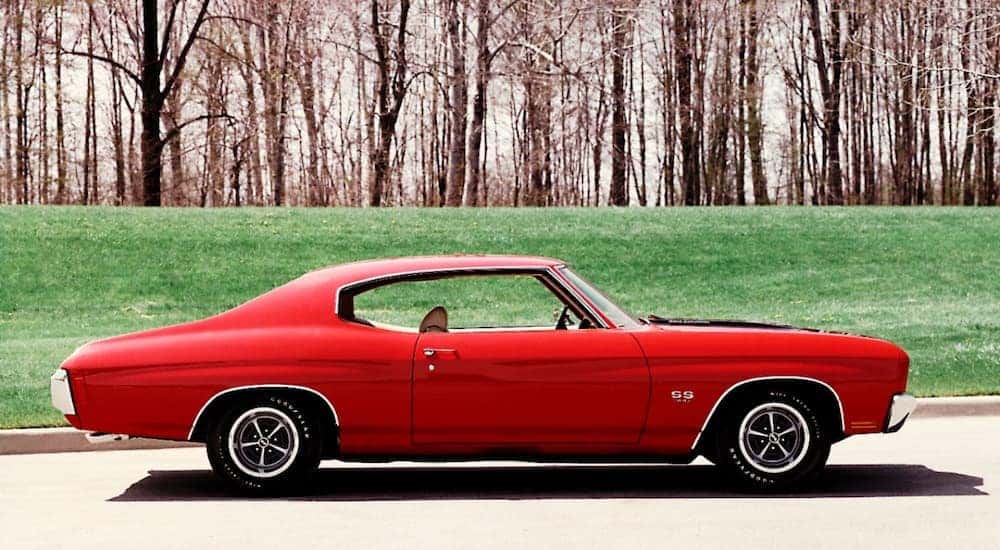 An red 1970 Chevy Chevelle SS is shown from the side parked near grass.