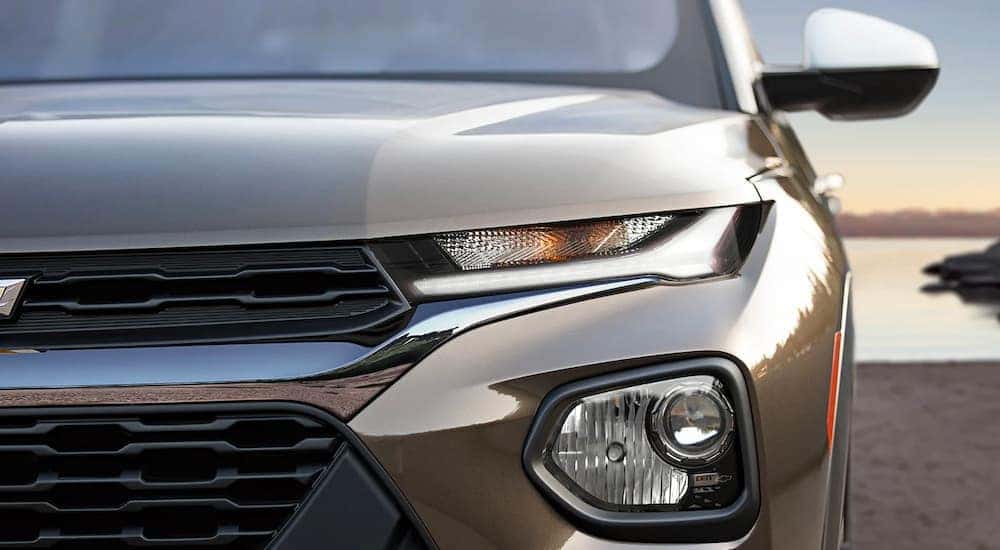A close up of the grille and headlight is shown on a brown 2022 Chevy Trailblazer.