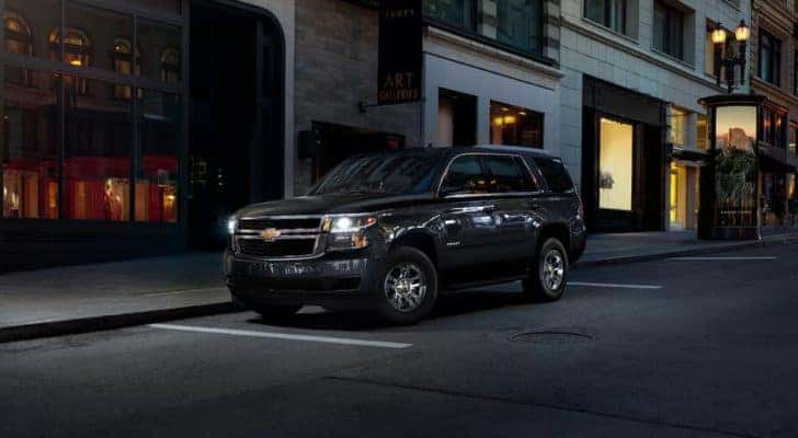 A black 2020 Chevy Tahoe is shown parked on the edge of a city street after leaving a used Chevy Tahoe dealer.