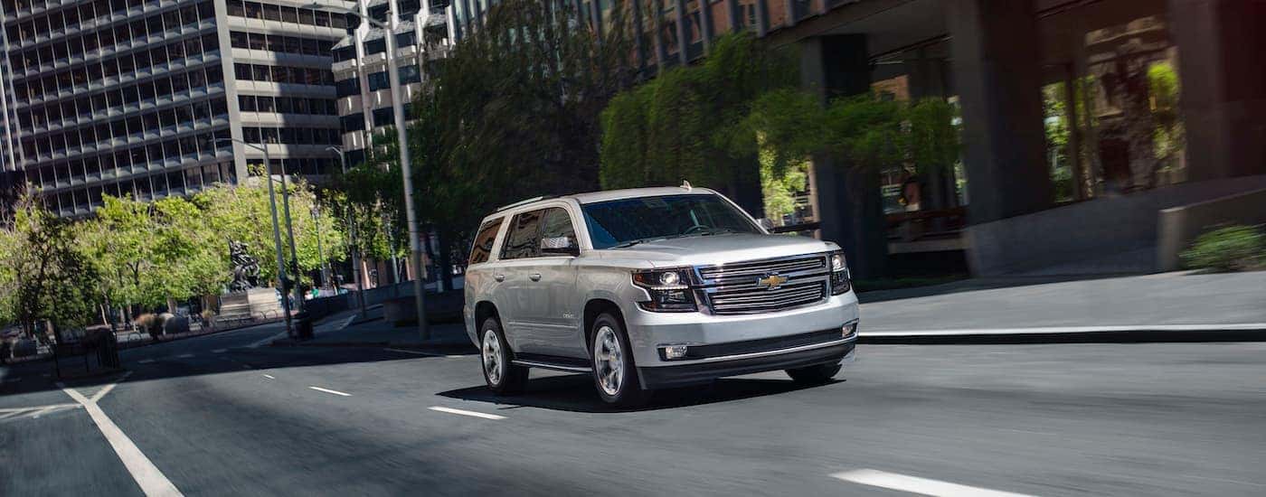A silver 2020 Chevy Tahoe is shown speeding down an open city road.