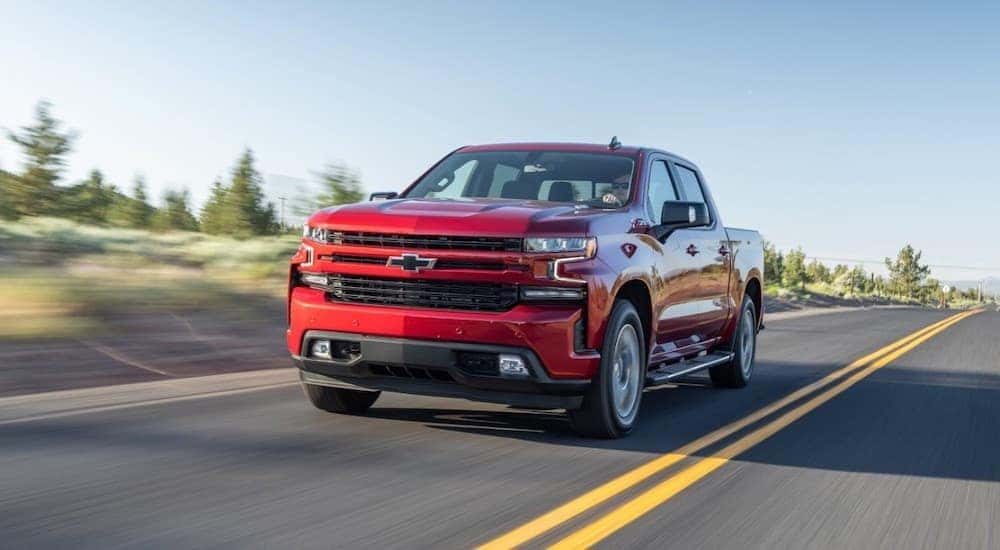 A red 2020 Chevy Silverado 1500 is shown from the front while it drives down the road.