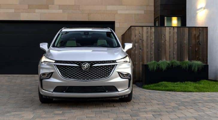 A silver 2022 Buick Enclave Avenir is shown from the front parked in a driveway.