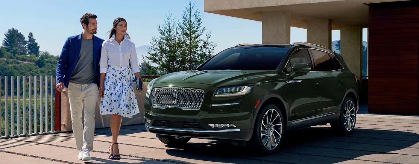 A green 2022 Lincoln Nautilus is shown parked in a modern driveway after viewing pre-owned luxury car sales.