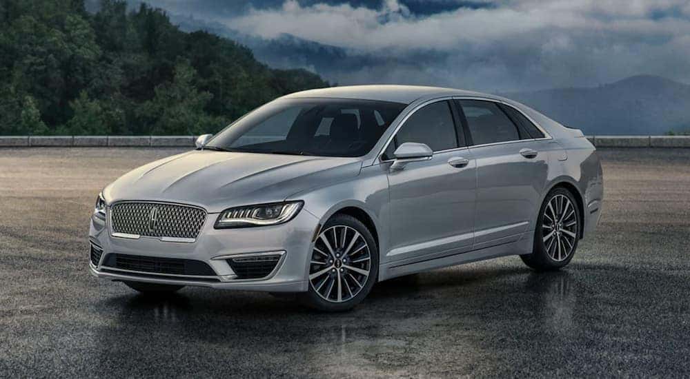 A grey pre-owned luxury car, a 2022 Lincoln MKZ is shown from the side parked at dusk.