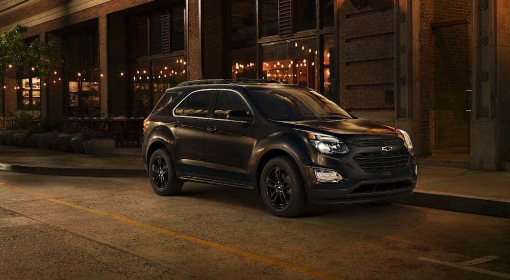 A black 2017 Chevy Equinox is shown parked on a city street at night.