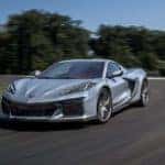 A silver 2023 Chevy Corvette Z06 is shown from the front driving on a racetrack after leaving a Suwanee Chevy dealership.