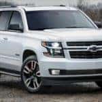 A white 2018 Chevy Tahoe is shown from the front parked on a dirt road.