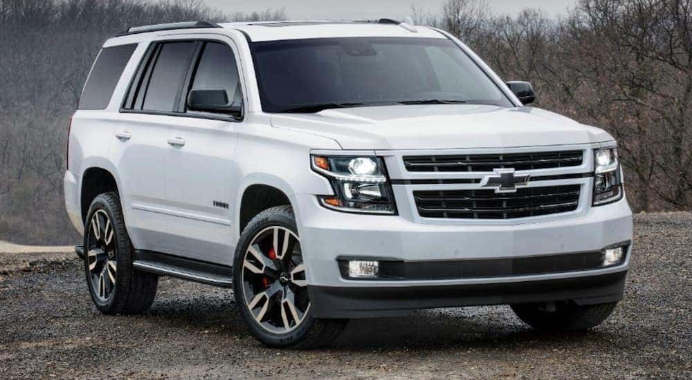 A white 2018 Chevy Tahoe is shown from the front parked on a dirt road.