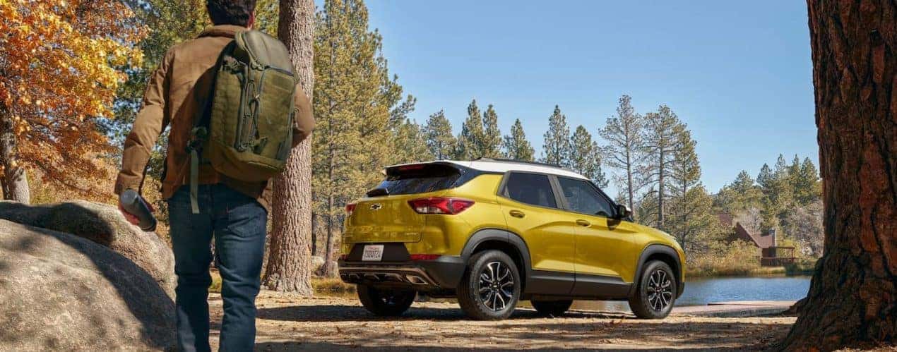 A yellow 2023 Chevy Trailblazer ACTIV is shown parked near a hiking trail.