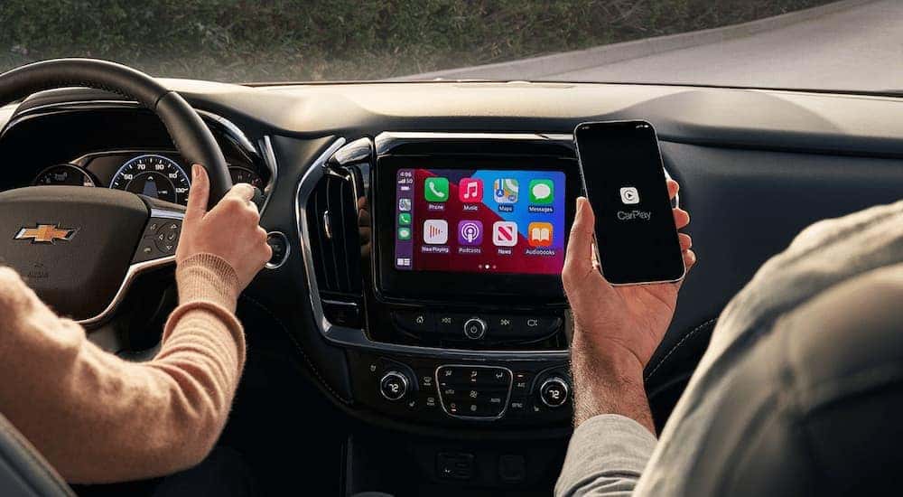A couple is shown driving in a 2021 Chevy Traverse.