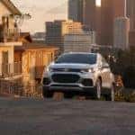 A silver 2022 Chevy Trax is shown driving up a city hill after leaving an Atlanta used car lot.