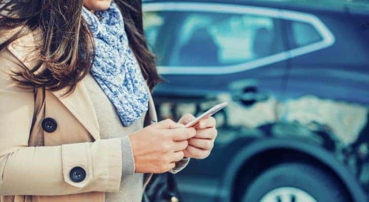 A person is shown searching 'sell my car' on their phone.