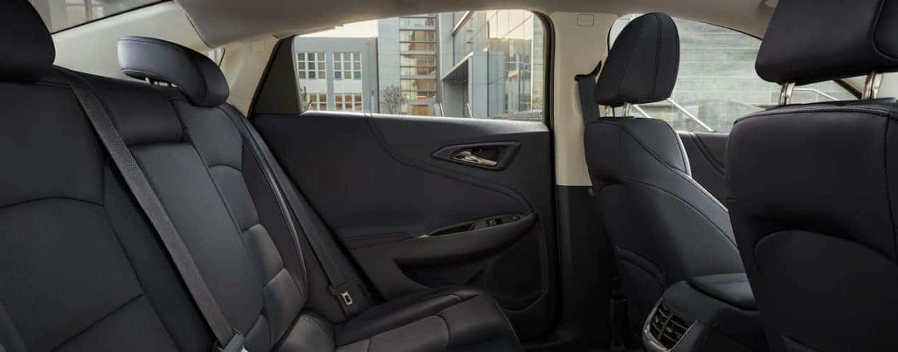 The black interior of a 2022 Chevy Malibu shows the back seats.
