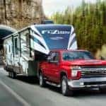 A red 2020 Chevy Silverado 2500 HD is shown from the front towing a trailer.