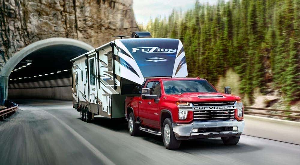 A red 2020 Chevy Silverado 2500 HD is shown from the front towing a trailer.