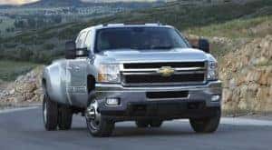A silver 2014 Chevy Silverado 3500 HD is shown parked on an open road.