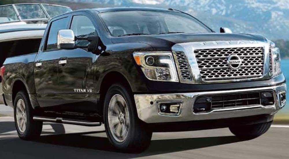 A black 2019 Nissan Titan is shown driving on an open road.