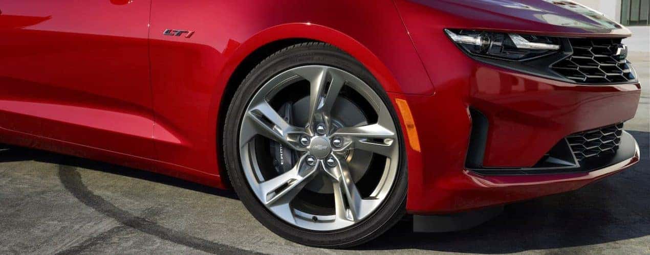 A close up shows the front passenger rim on a red 2023 Chevy Camaro LT1.