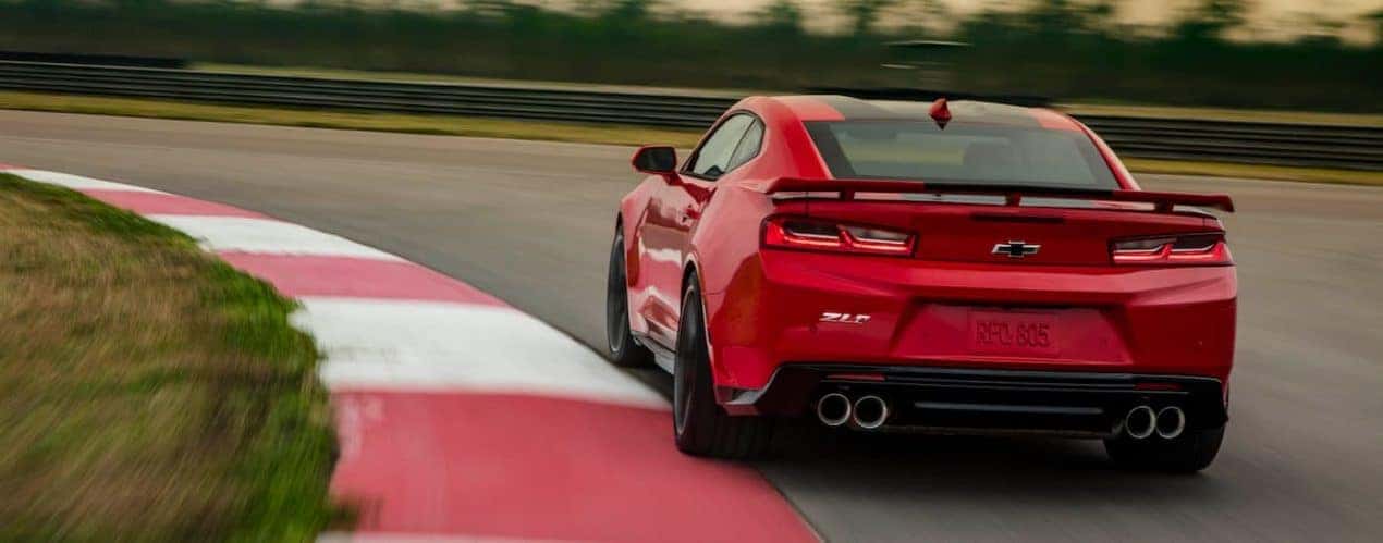 A red 2023 Chevy Camaro ZL1 is shown from the rear on a racetrack.