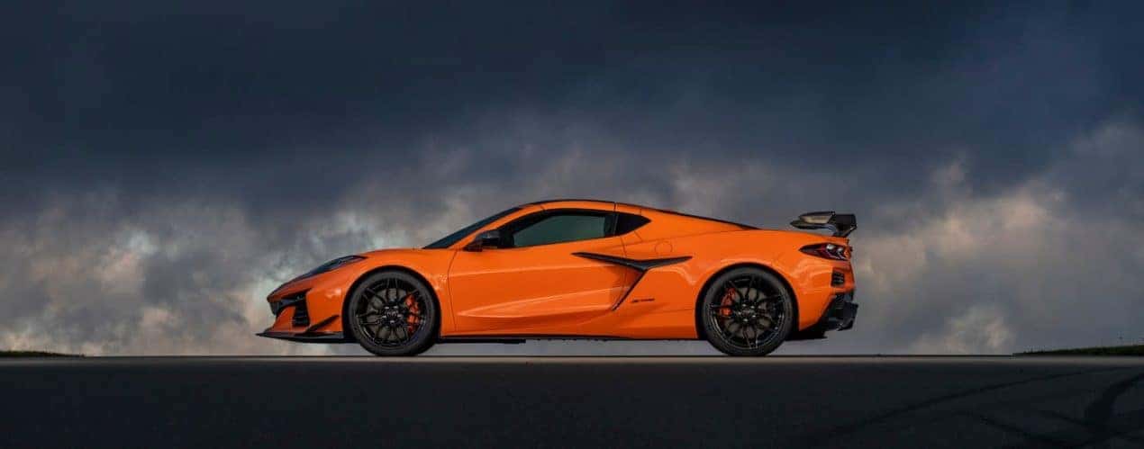An orange 2023 Chevy Corvette Stingray Z06 is shown parked on a cloudy day.