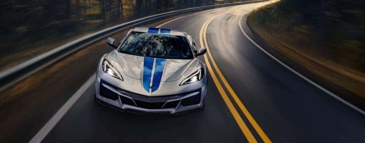 A silver 2024 Chevy Corvette E-Ray 3LZ is shown from the front on a wet road.