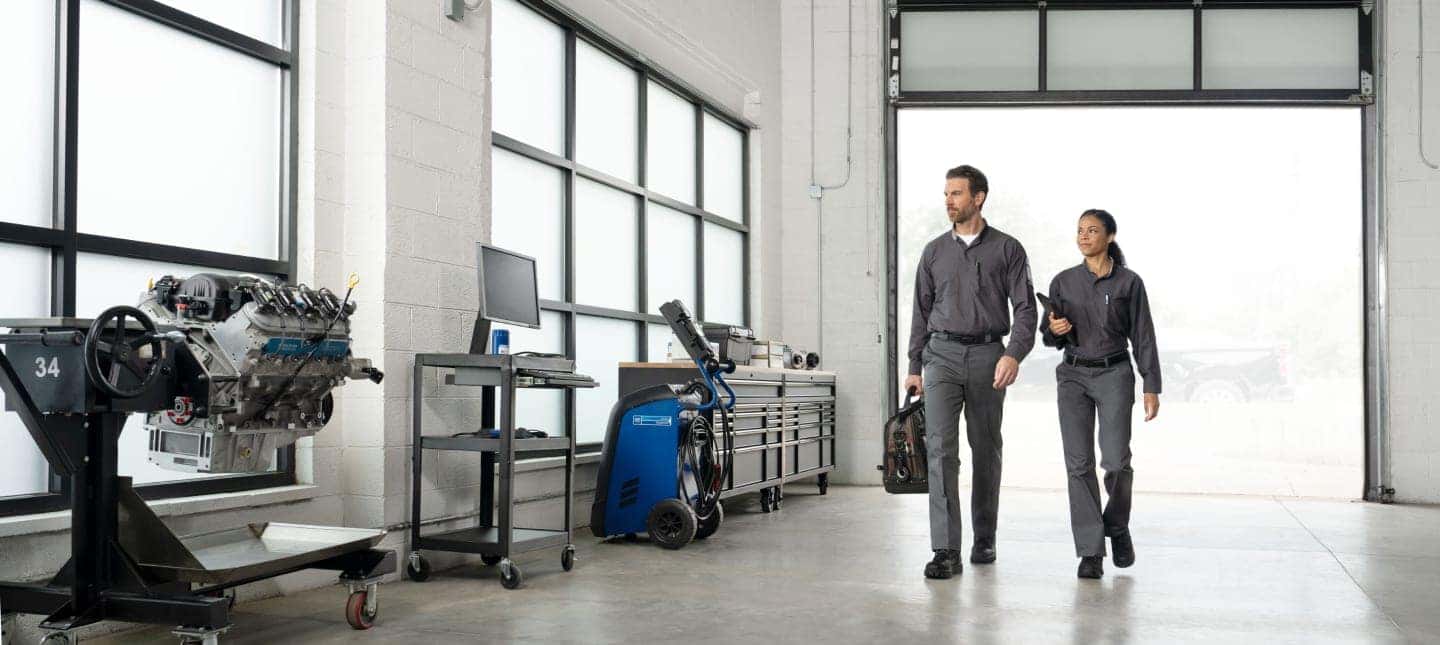 two GM technicians in a service bay