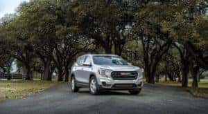 A silver 2022 GMC Terrain is shown parked on a tree-lined road after leaving a GMC dealer near you.