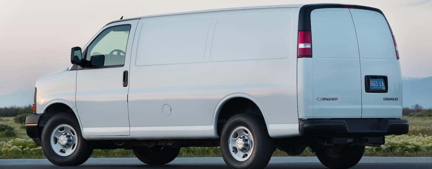 A white 2016 Chevy Express is shown from the side parked at sunset.