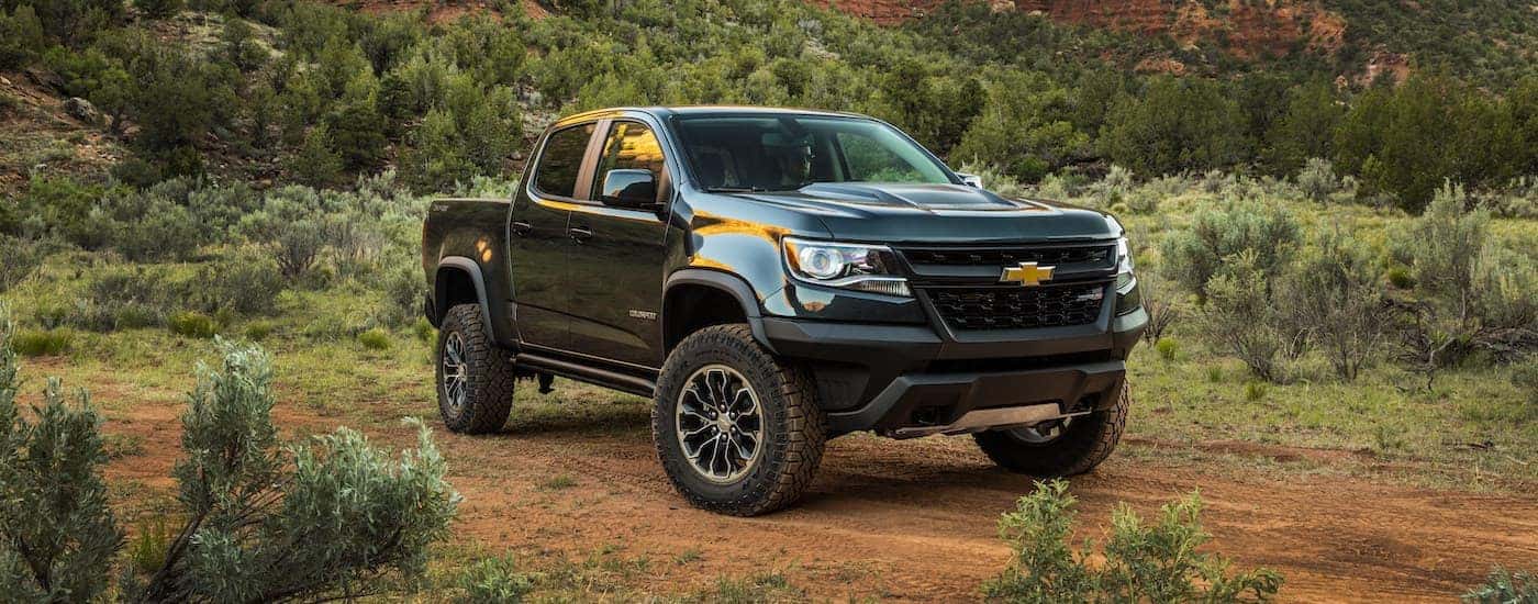 A green 2020 Chevy Colorado ZR2 is shown from the front parked in a field after leaving a used GMC dealer.