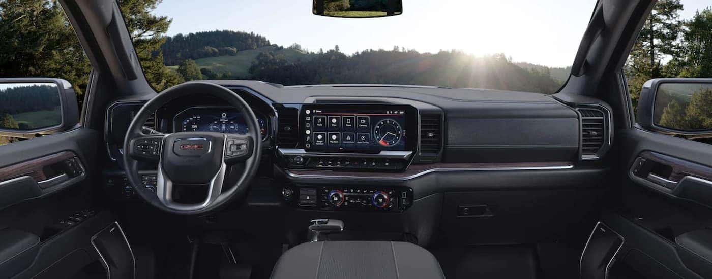 The black interior of a 2023 GMC Sierra 1500 shows the steering wheel.