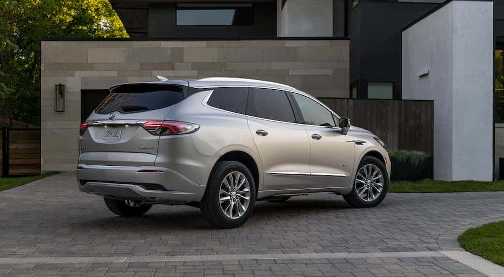 A silver 2023 Buick Enclave is shown from the rear at an angle.