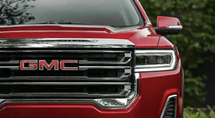 A close up of the front of red 2023 GMC Acadia SLT is shown at a GMC dealer near Stanley.