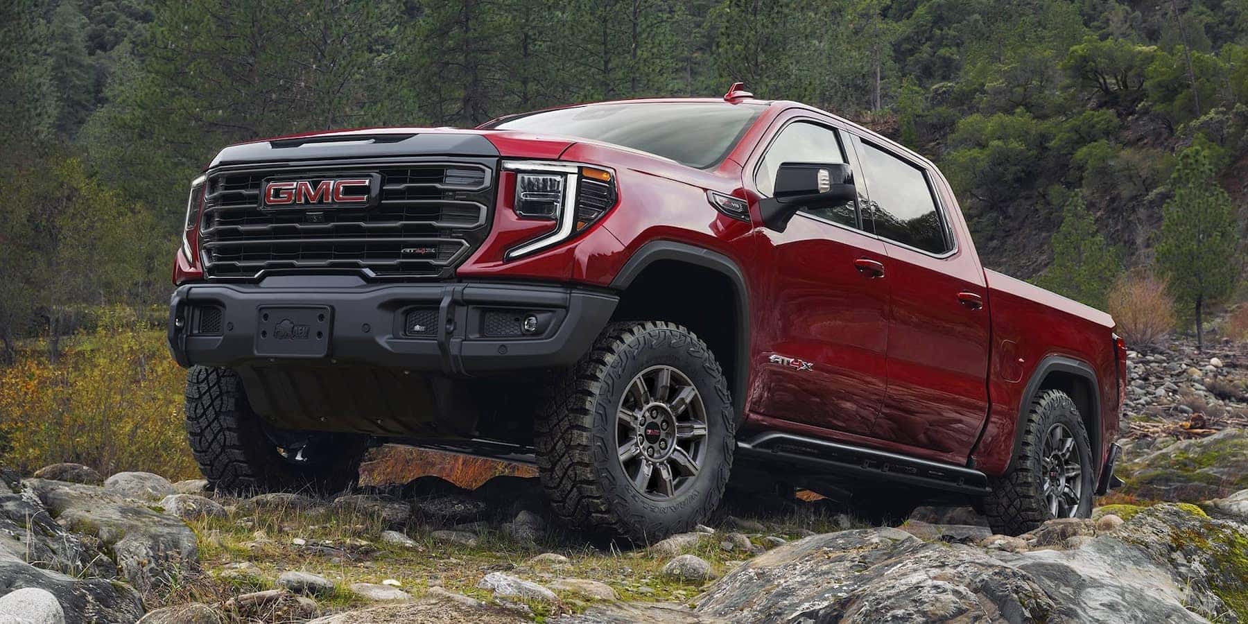 A red 2025 GMC Sierra 1500 parked on a rocky hill