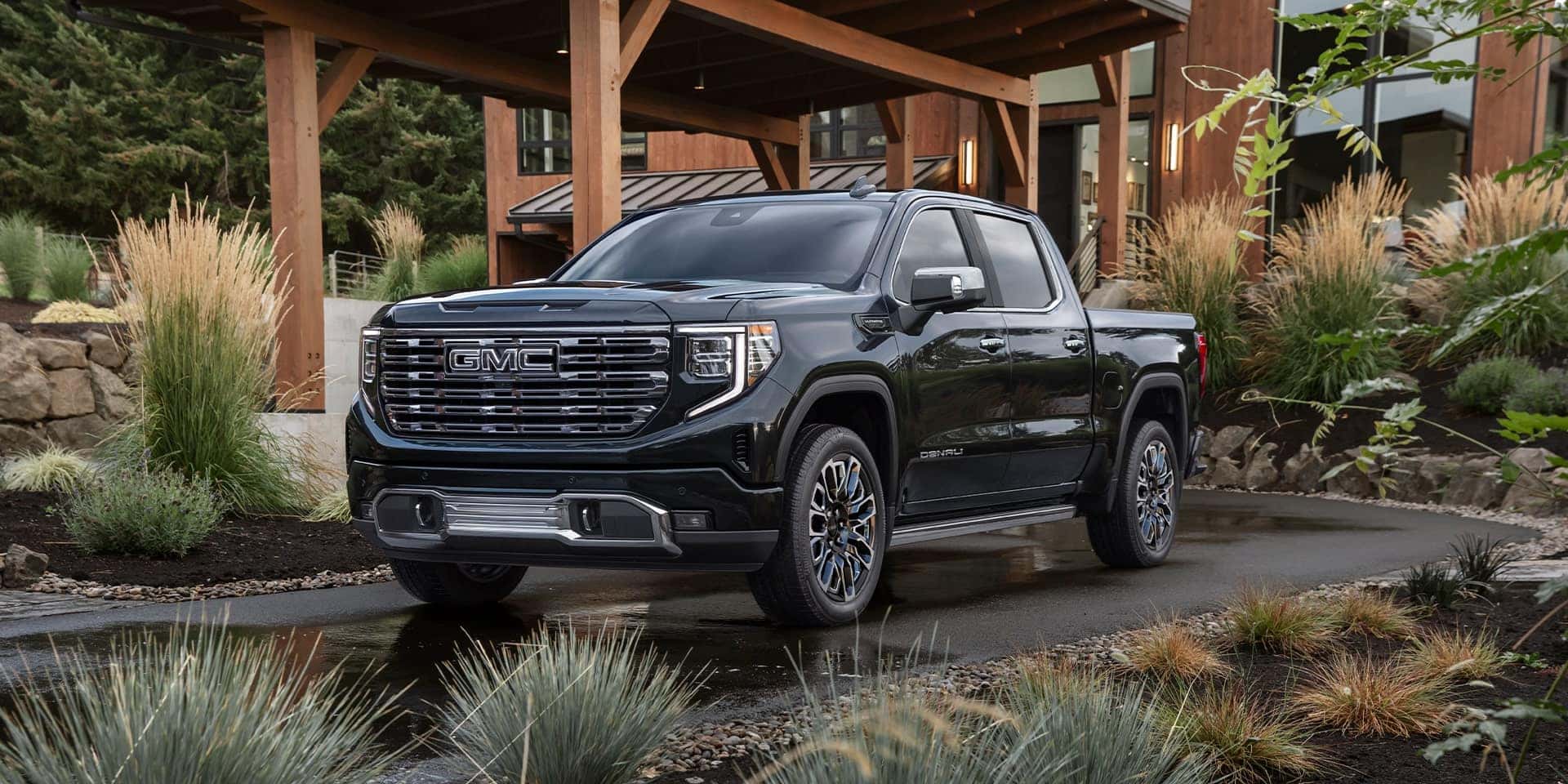 A black GMC Sierra 1500 parked in a nice house's driveway