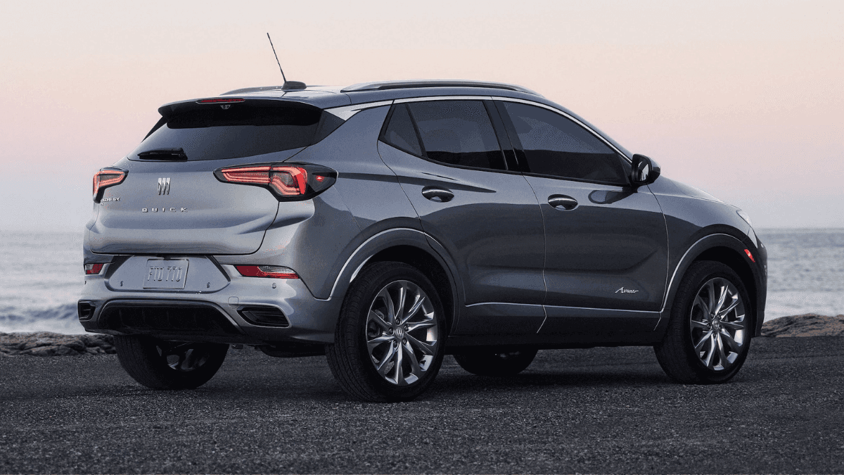 A light gray blue Buick Encore parked on a black sand beach