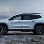 A white GMC Acadia parked at a beach