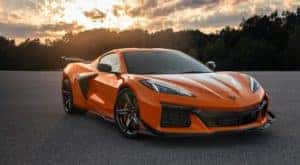 An orange 2023 Chevy Corvette Z06 is shown in an empty lot after visiting a Chevy dealer near you.